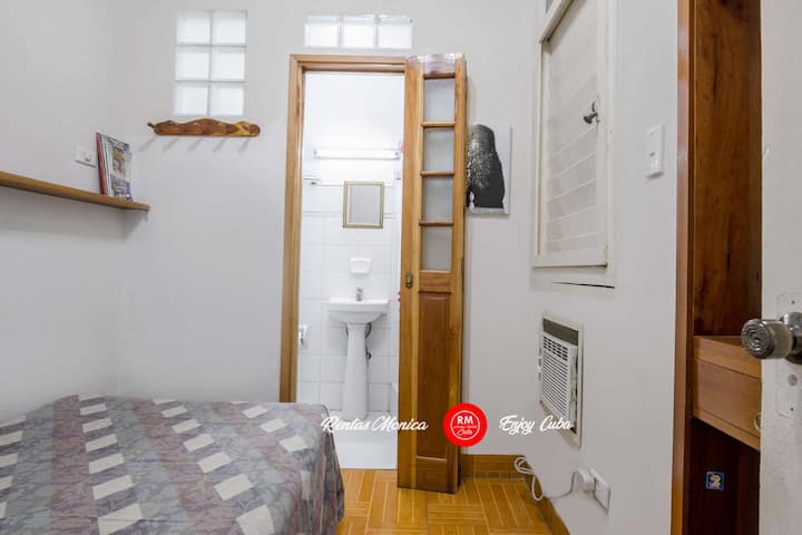 Dormitorio pequeño #2 con una cama de una plaza, aire acondicionado, armario y baño privado.