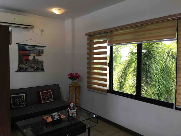 ห้องนั่งเล่นที่มีเตียงโซฟาและหน้าต่างบานใหญ่