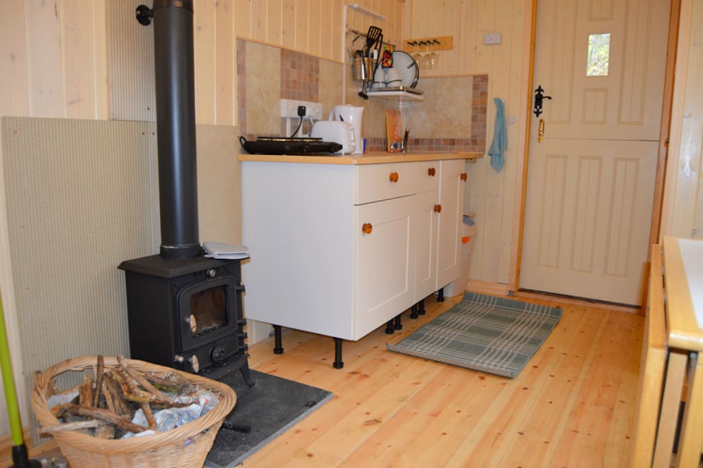 Kitchen area , log burner and door to bathroom
