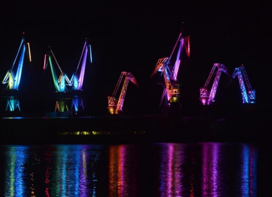 Lighting giants,shipyard;s cranes that are lightened up during the night