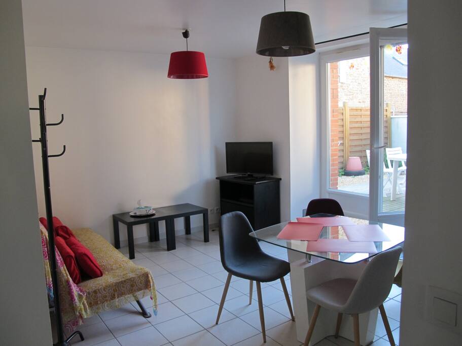 table à manger avec 4 chaises et coin salon avec tv