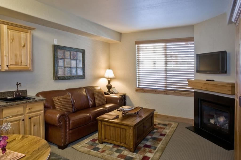 Relax in the cozy living area, complete with fireplace and TV