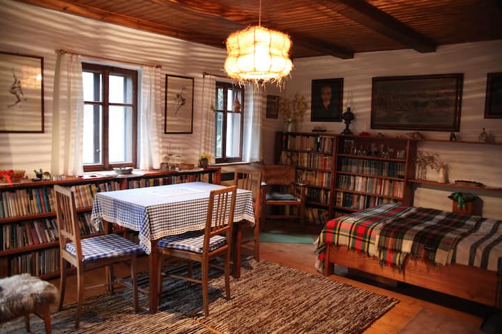 Un salon rempli de livres,  avec une chaise et un lit double.

Eng
Un salon rempli de livres et de fauteuils et d'un lit queen size.