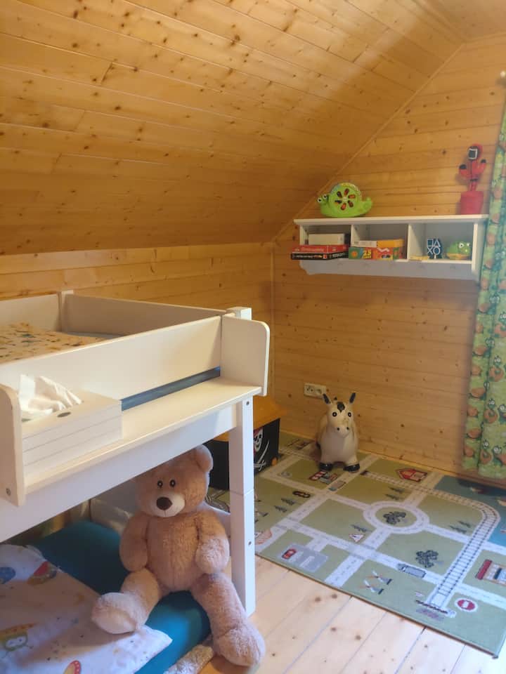 Izba pre batoľatá s vyvýšenou posteľou s možnosťou pridania matraca pod posteľou. Detský kútik pre deti. 