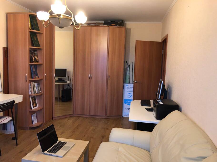 Room with sofa, TV and two desks for working