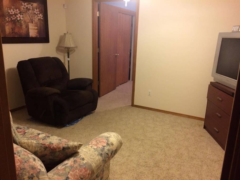 Living room area with sofa, recliner, TV.