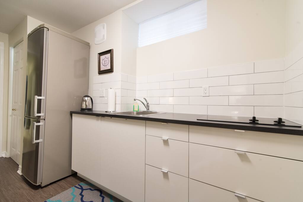 Kitchenette with full fridge, cooktop, utensils, toaster and basic cookware