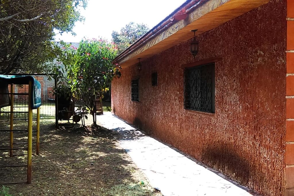 Fachada lateral interior de la casa, con juegos para niños