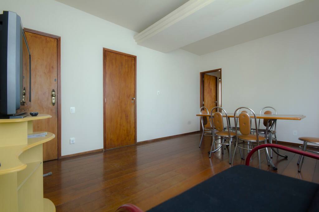 Sala de estar com mesa e TV.