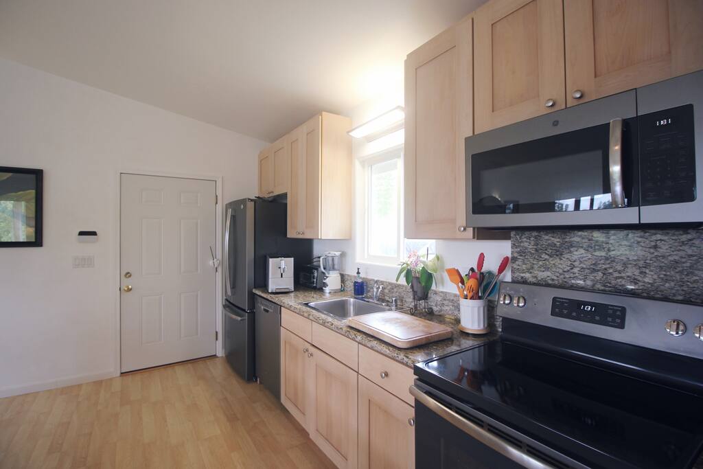 Full kitchen with granite counter top and Jura coffee maker filled with organic coffee our farm