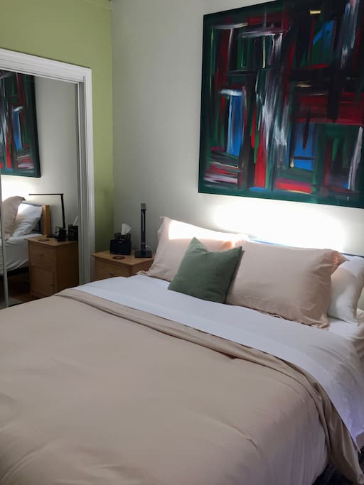 Master bedroom with modern queen-sized bed with memory foam mattress. Tasteful decor with unique artwork