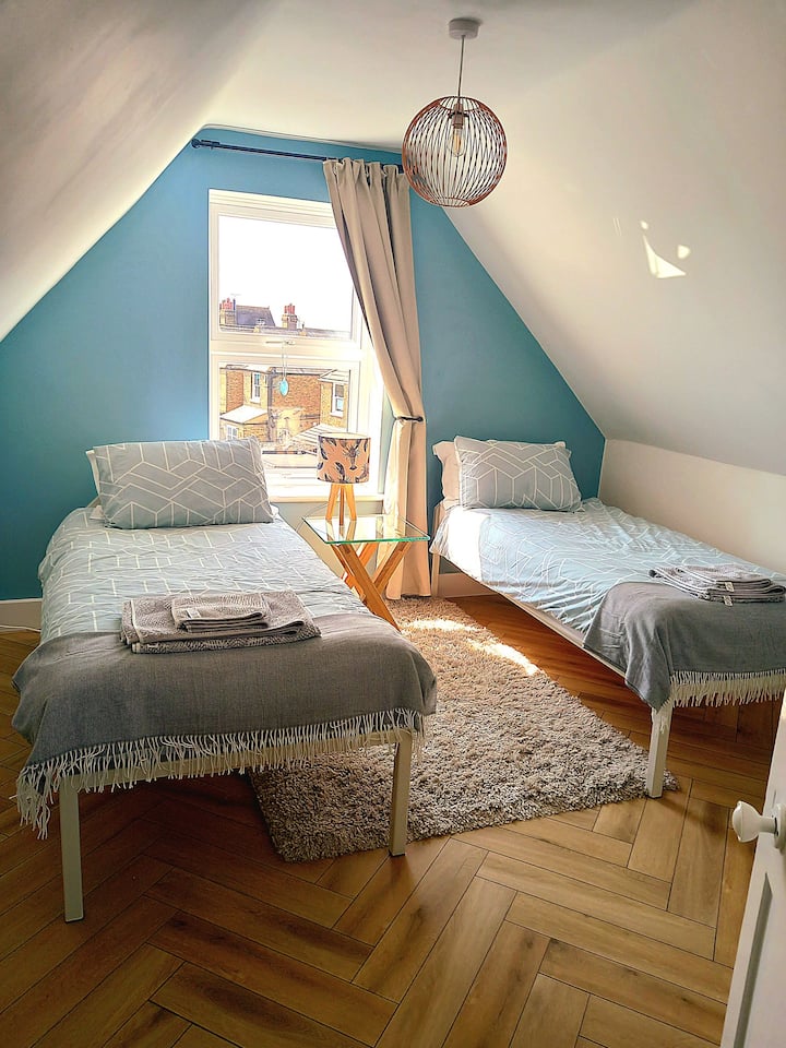 阳光明媚的卧室配有两张单人床、衣物储藏室和悬挂空间。 这间卧室位于房源前方，可俯瞰繁忙的大街。 请注意，卫生间与卧室不在同一楼层。