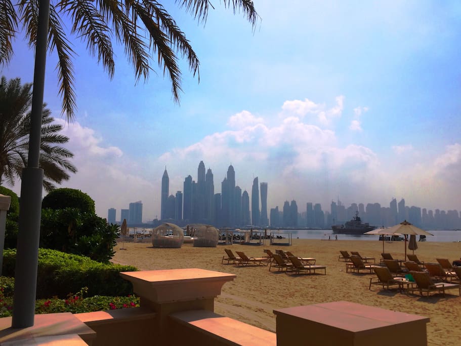 Private beach with sunbeds and amazing views to the sea and and skyscraper skyline.