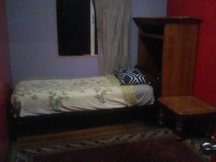 Соба со единечен кревет и место каде што можете да ја закачите облеката... 