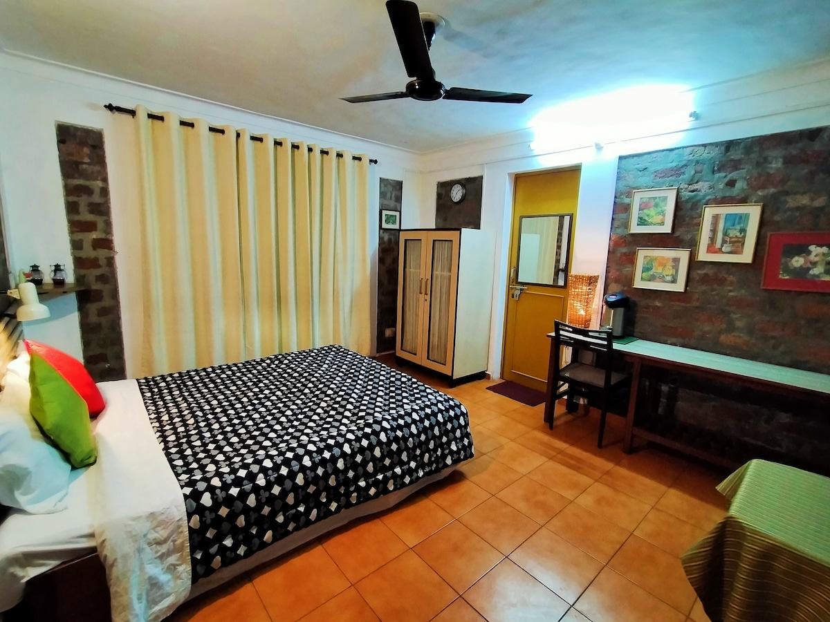 Spavaća soba 1 sa spojenom kupaonicom. Vidljiv je i ormar za goste i višenamjenski stol kojim se gosti koriste kao radni prostor i „prostor za bacanje”, osim što je obuća i prazna prtljaga.