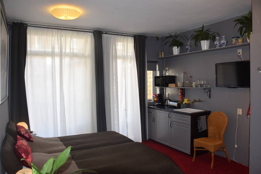 Studio - Overview with the beds on the left, kitchen on the right and the doors to the balcony on the back. Bathroom and toilet in the bottom right corner