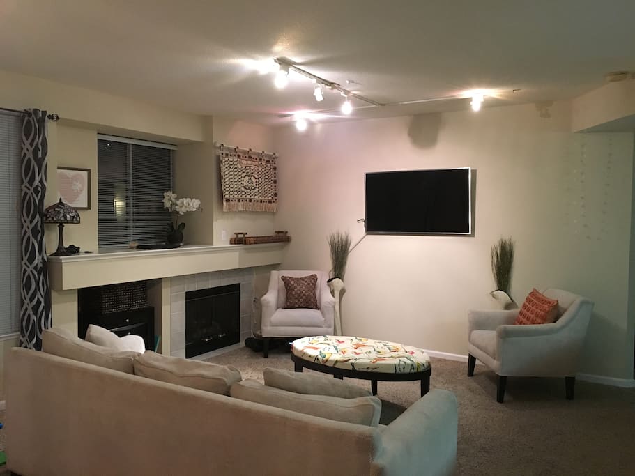 4K UHD TV, spacious couch, electric fireplace.