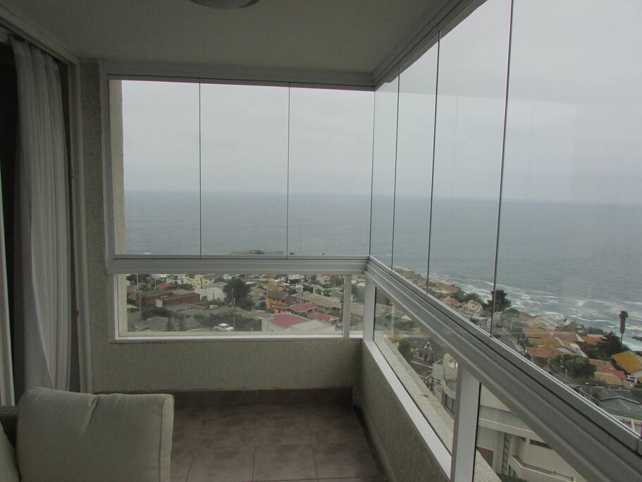 Terraza protegida con cortina de cristal plegables y sin perfiles vertical