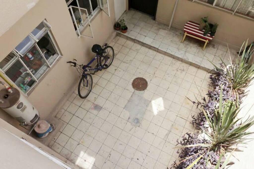 Patio a la salida de una habitación, cuenta con mesa y asador