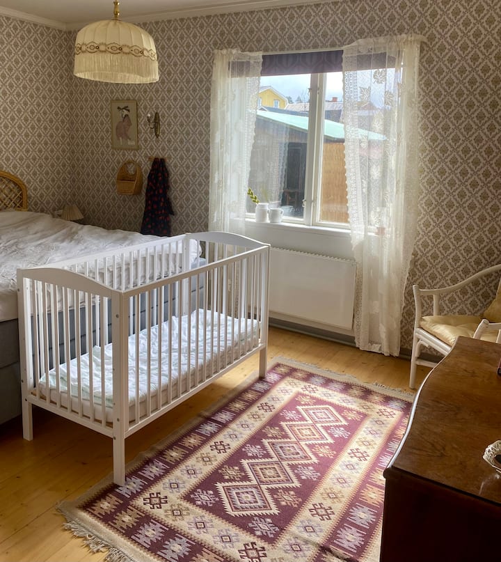 Dormitorio con una cama tamaño king y cuna