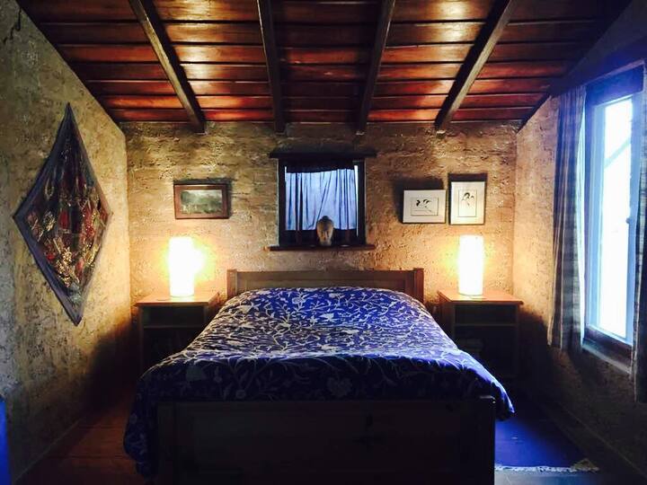 The sleeping area of the guest bedroom - with a double bed, side tables and reading lights, well ventilated and with a heater.