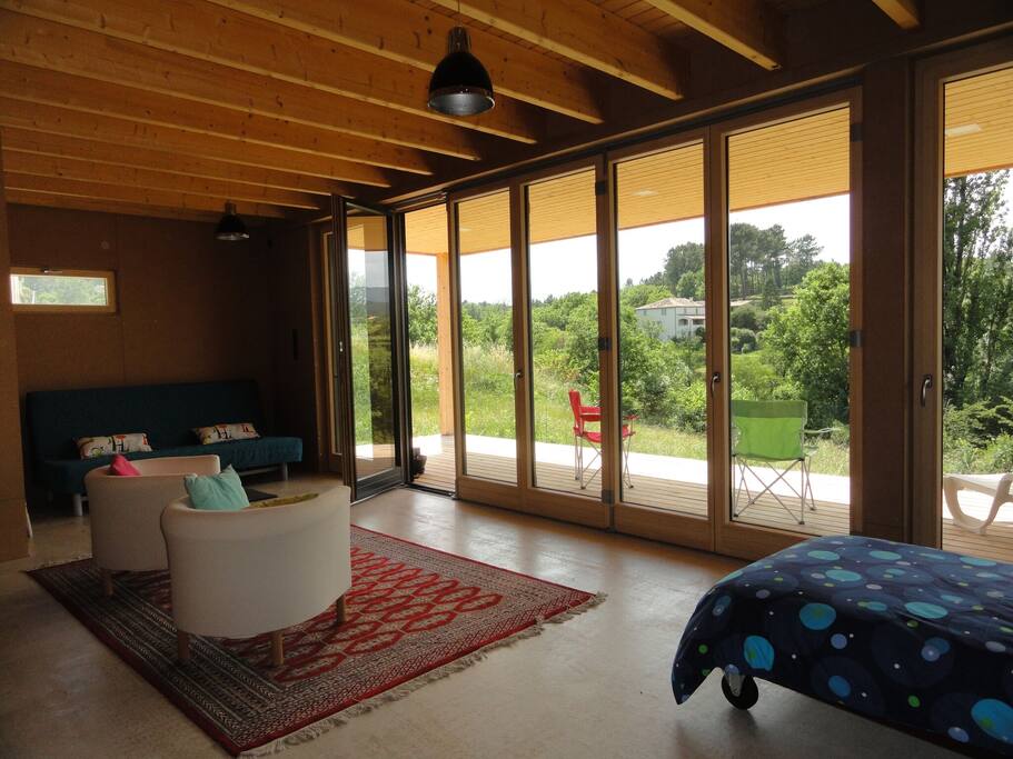 Espace de vie au RDC avec lit simple et canapé convertible 140x200, accès direct au jardin et superbe vue