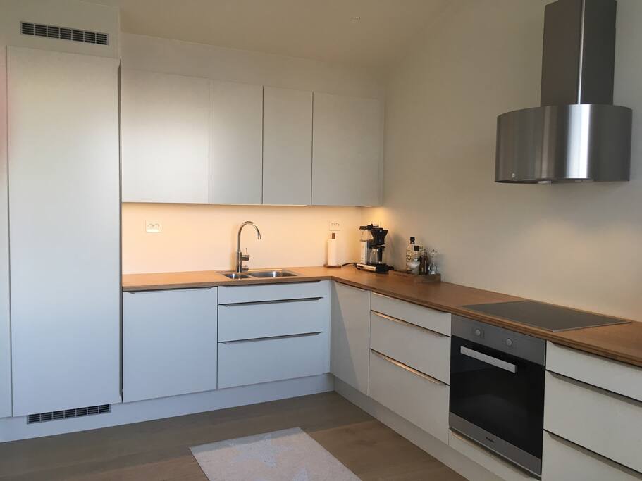 Stort kjøkken med moderne hvitevarer. God plass til matlaging. Large kitchen with modern appliances.