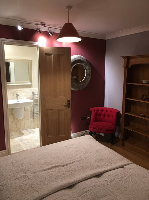 The bright en-suite contrasts with the subtle tones in the bedroom