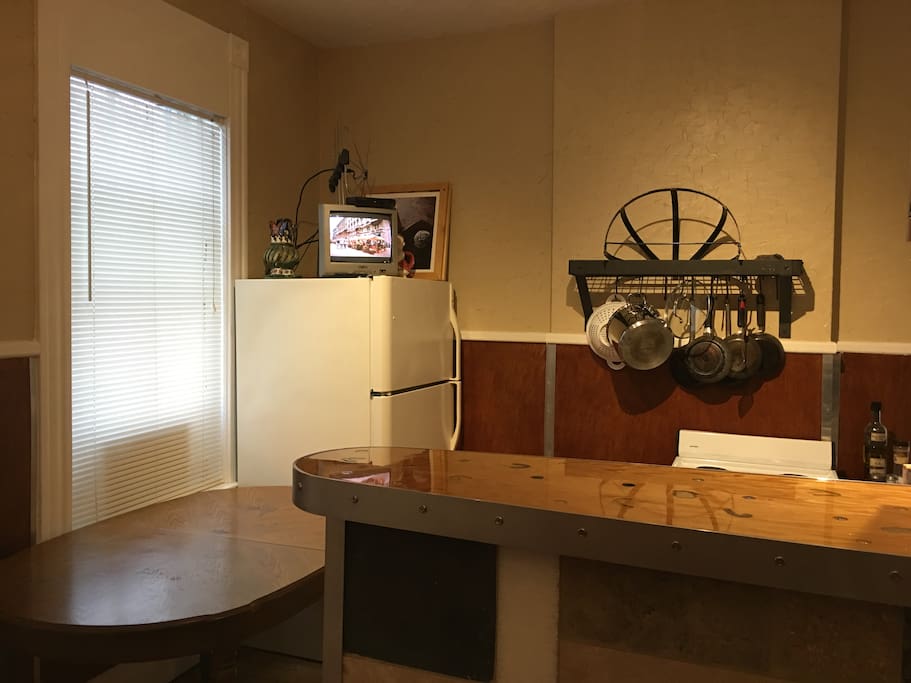 This is also the kitchen. There is a small TV on the fridge...
