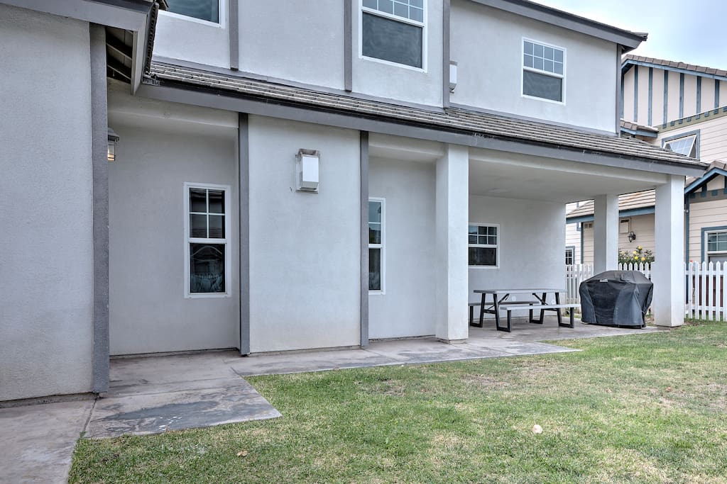 The rear of the house has a large grill and picnic table for outdoor dining.