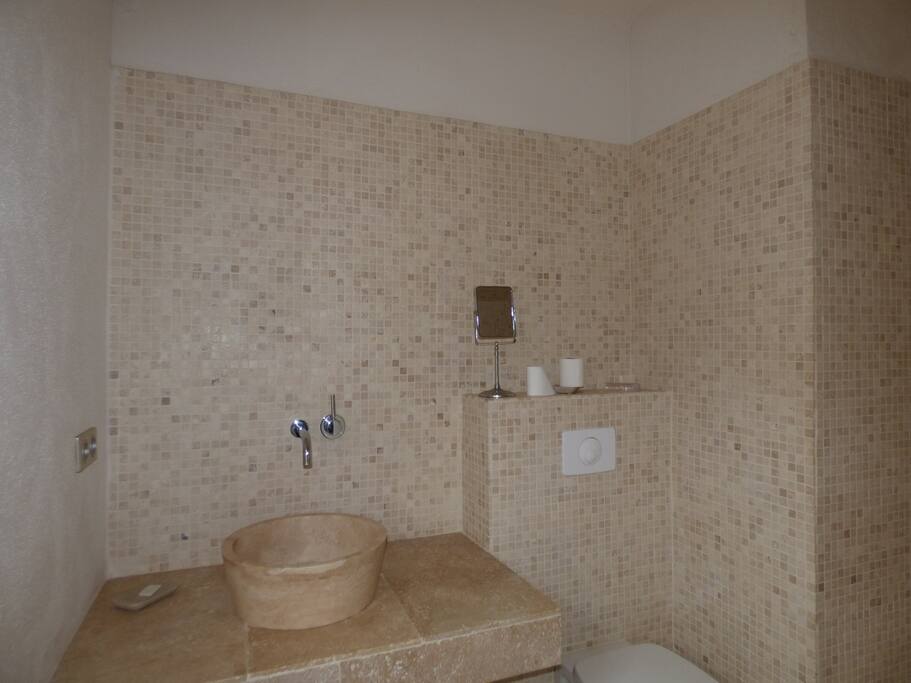 La salle d'eau avec toilettes à la chambre avec grand lit au rez de chaussée