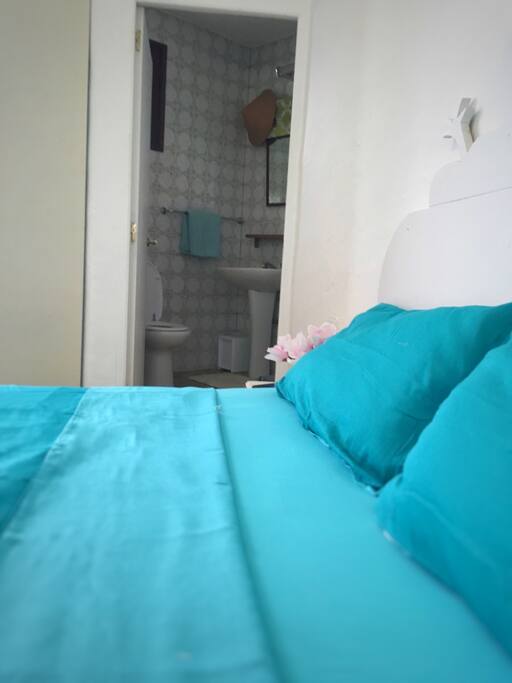 Lovely bright room with a king size bed, your own bathroom, seats and a table, lots of storage and access from the room to the beautiful shared roof terrace, garden & pool.