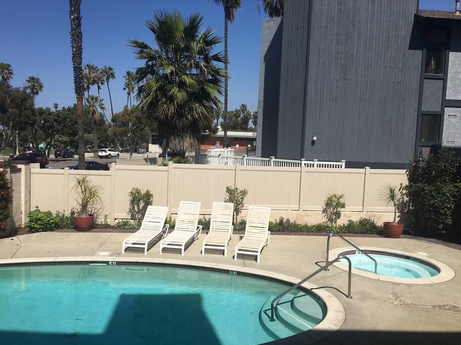 Swimming pool and hot tub, nice pool deck, with loungers, chairs and tables.