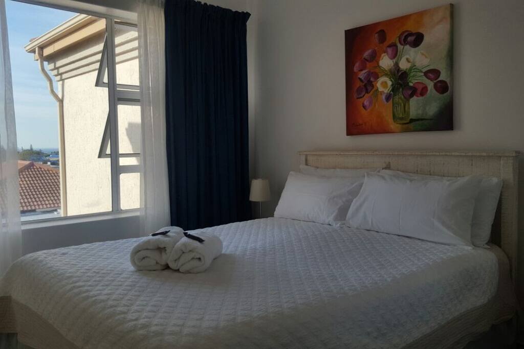 Main bedroom with double bed, built in cupboards. Large windows and a mirror