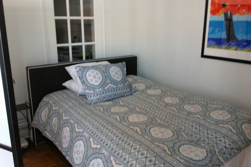 Super comfortable new bed, separated from the living room area by a divider