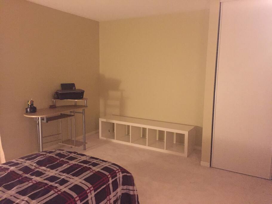 Spacious guest bedroom with a single bed, a desk, lots of storage space, and a private ensuite full bathroom.