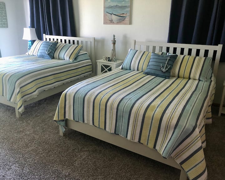 Two Queen beds with sliding glass doors out to the balcony. Twin size roll-away stored in the closet and can be used anywhere in the house. 