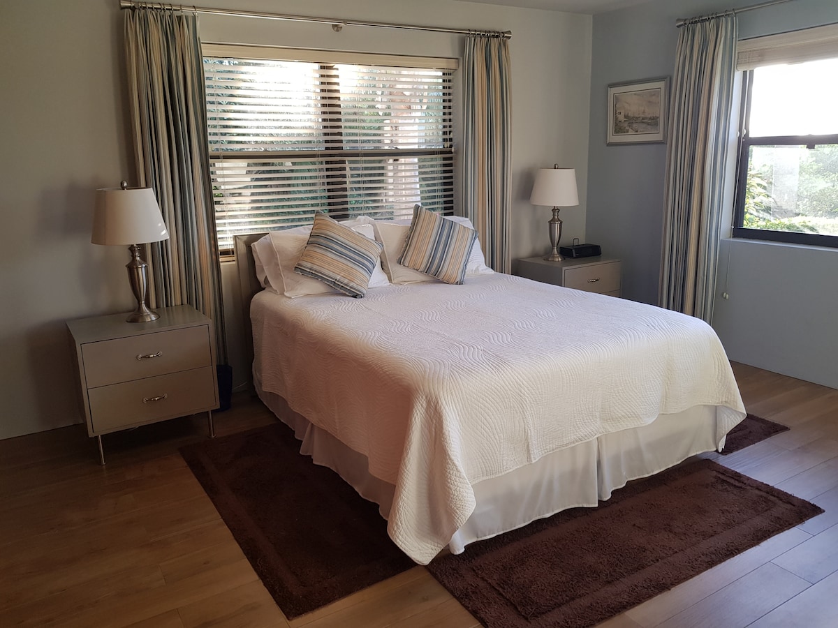 غرفة نوم رئيسية واسعة بسرير بحجم كبير.