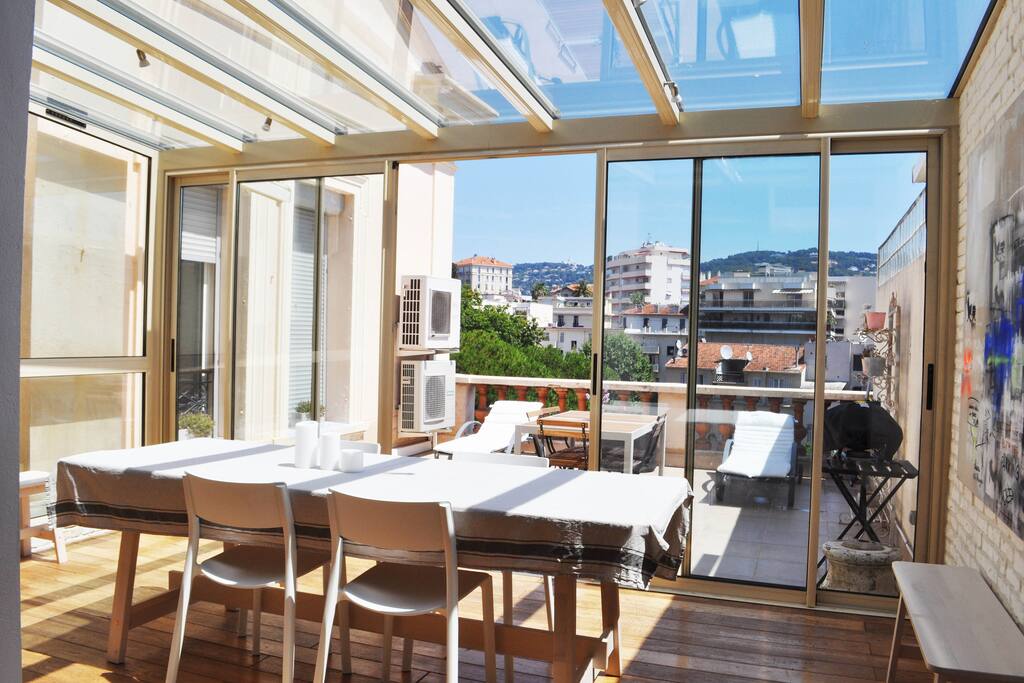 La vue de la véranda et de la terrasse (25m2), chacune meublée de table et d'assises