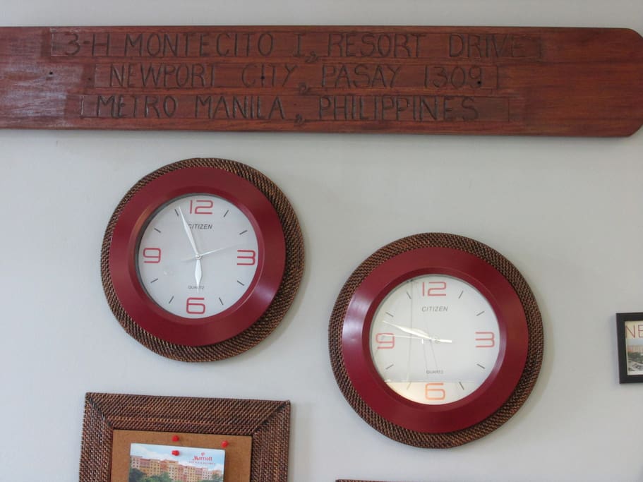 the complete address carved on old wood. visible are 2 wall clocks one for local time and the other where the heart is.