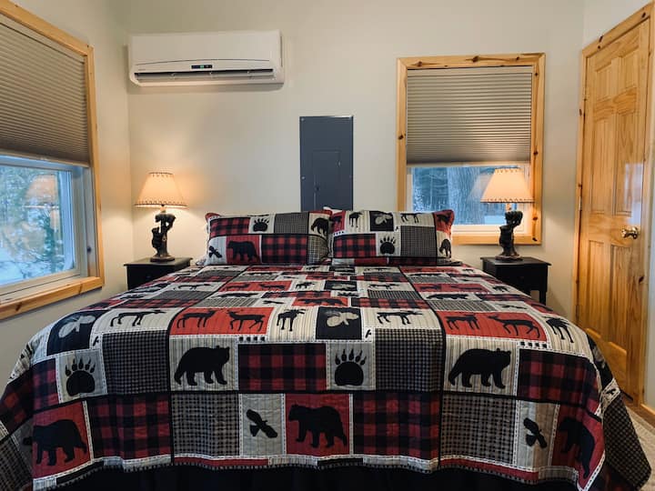 ห้องนอนชั้นหลักพร้อมเตียงคิงไซและทีวีพร้อมห้องน้ำที่อยู่ติดกัน