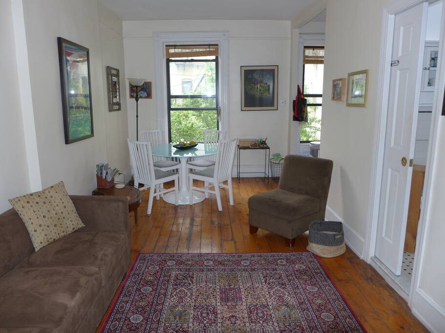 The bright living/dining room. The bathroom door is on the right and the kitchen on the back to the right.