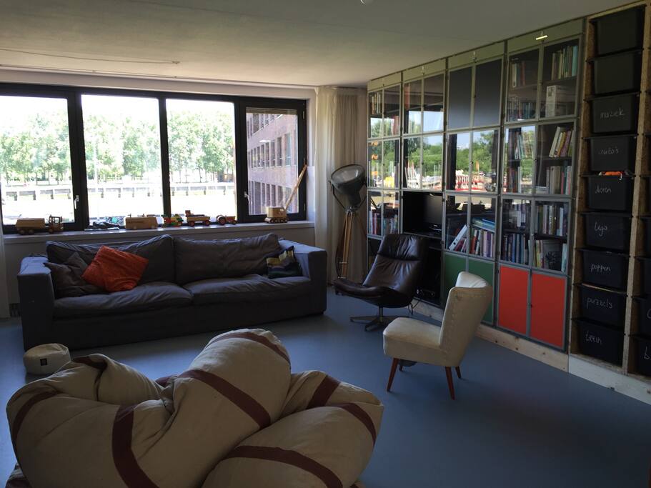 Living room, good views over the river, park and Rotterdam's famous "Euromast" tower. Sit and watch the boats go by. Enjoy our books and -for kids- the toys