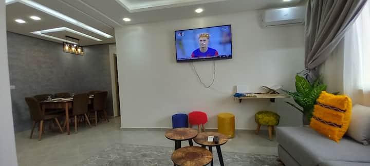 Дневната соба со 50-инчен паметен телевизор со (IPTV/Netflix), клима уред, работен простор и 3 мали маси додаваат практичен детаљ, така што прозорецот нуди изобилна природна светлина, што го прави просторот совршено осветлен.