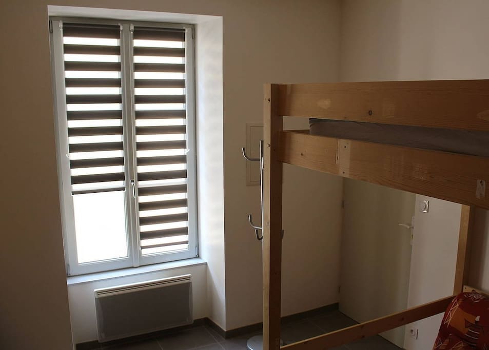 Entrée studio avec coin salon sous lit mezzanine.