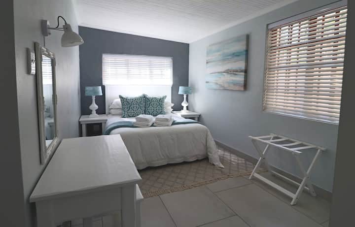 Ფართო საძინებელი საწოლით, საგარდერობო მაგიდით და საკმარისი სათავსოებით მთელ სიგრძეზე.