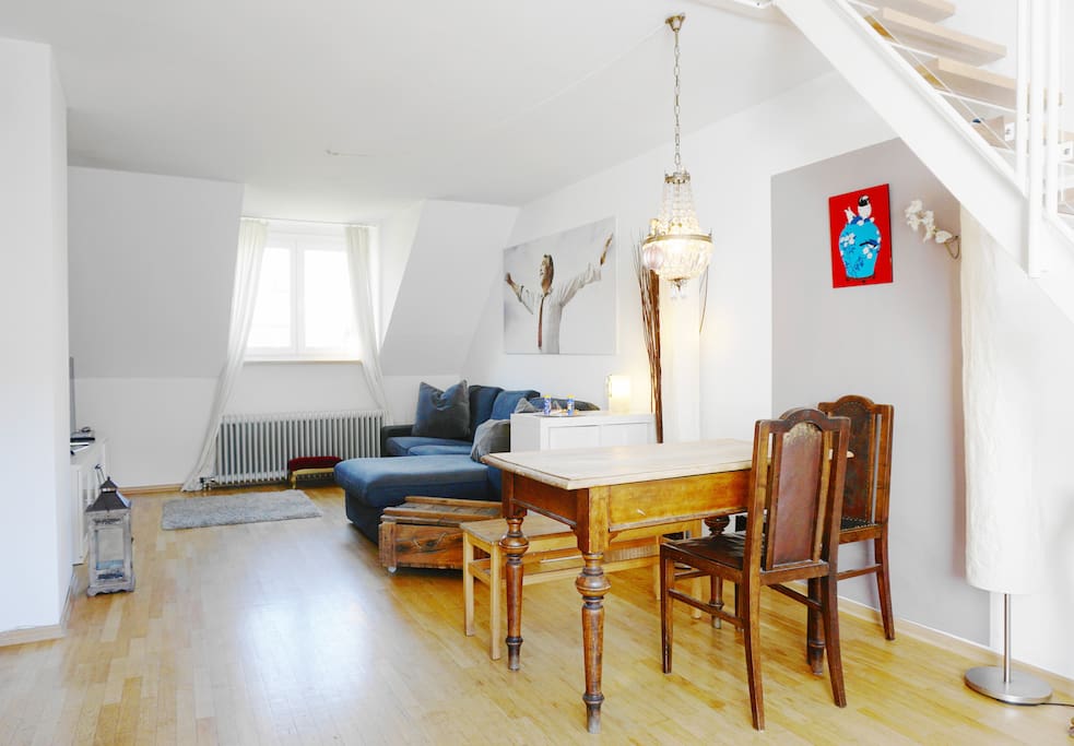 The old-fashioned table is combined with stylish light and modern art.