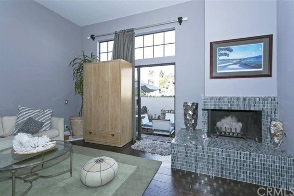 Lovely living room with television in cabinet. Goes out to outdoor patio and gas barbecue.