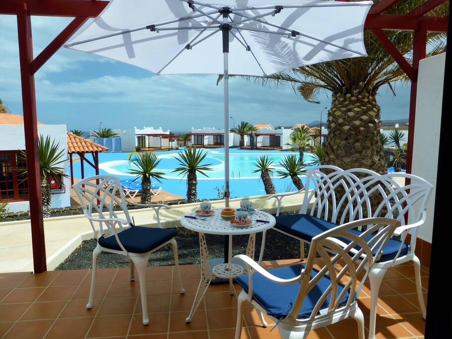Terrasse située plein sud équipée de confortables fauteuils et parasol.