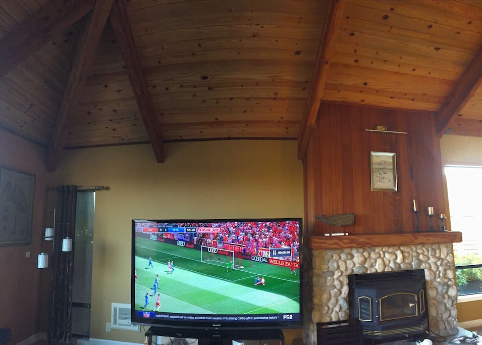 Family room with beautiful fireplace and 80 inch flatscreen Smart TV
